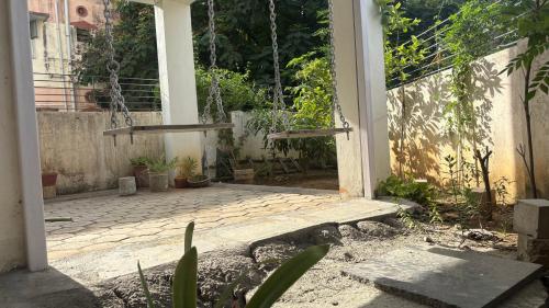 a porch with a swing and some plants at SHI's Agam Bed & Breakfast at Chennai in Chennai