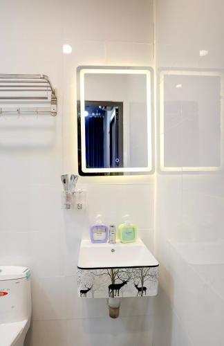 a white bathroom with a sink and a mirror at Rainbow Beach Mũi Né - Homestay & Coffee in Ấp Khánh Phước (1)