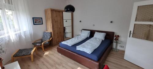 a bedroom with a bed with blue sheets and a chair at Sweet home apartment Kobylisy in Prague