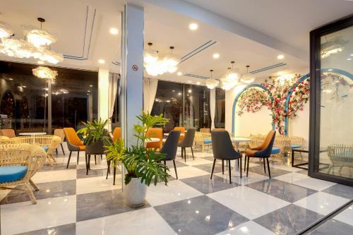 a restaurant with chairs and tables in a room at Rainbow Beach Mũi Né - Homestay & Coffee in Ấp Khánh Phước (1)