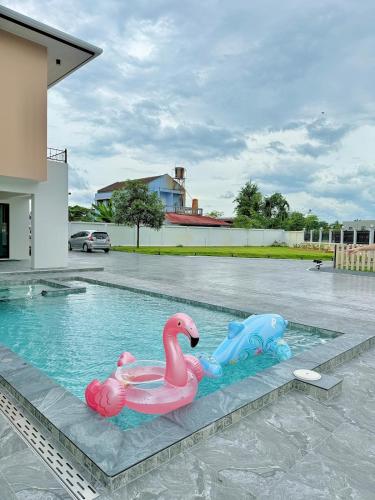 two plastic swans in a swimming pool at The Swan Pool Villa Hatyai เดอะสวอน พูลวิลล่าหาดใหญ่ in Ban Kohong