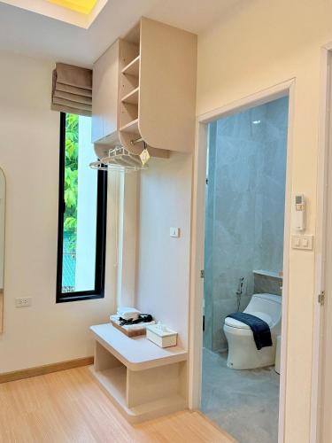 a bathroom with a toilet and a window at The Swan Pool Villa Hatyai เดอะสวอน พูลวิลล่าหาดใหญ่ in Ban Kohong