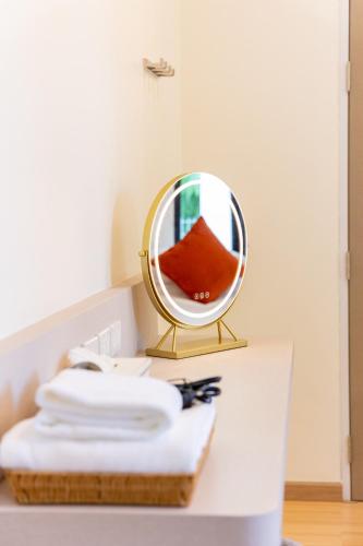 a mirror sitting on top of a table with towels at The Swan Pool Villa Hatyai เดอะสวอน พูลวิลล่าหาดใหญ่ in Ban Kohong