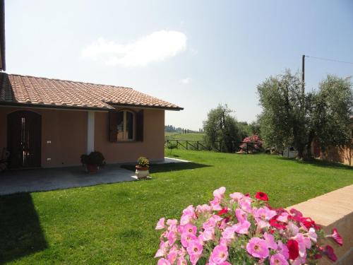 a house with pink flowers in the yard at Poggio Novello in Peccioli
