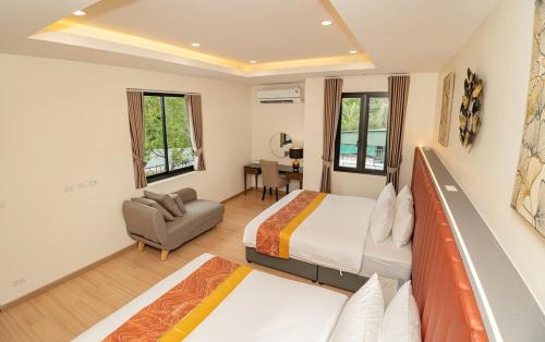 a hotel room with two beds and a couch at The Swan Pool Villa Hatyai เดอะสวอน พูลวิลล่าหาดใหญ่ in Ban Kohong