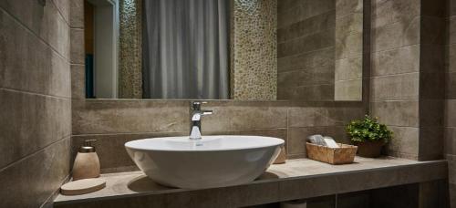 a bathroom with a white sink and a mirror at Aiolis Studios in Porto Koufo