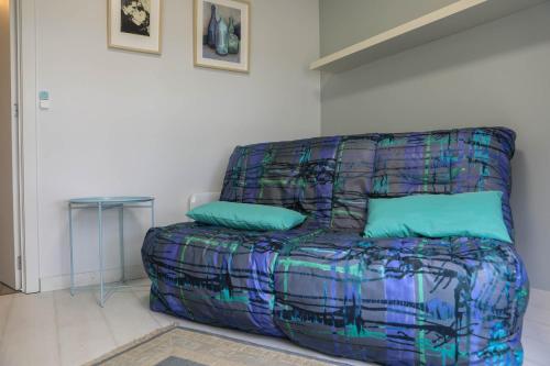 a colorful couch in a room with a table at Harbour View Stay - Stylish apartment with stunning views in the marina of Zeebrugge in Zeebrugge