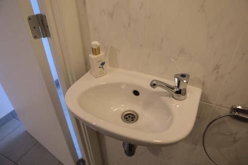 a bathroom sink with a bottle of soap on it at Harbour View Stay - Stylish apartment with stunning views in the marina of Zeebrugge in Zeebrugge