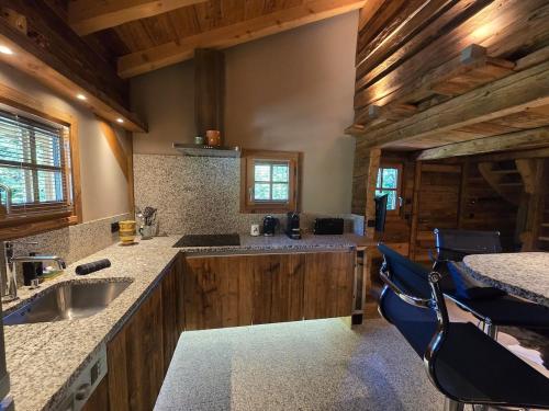 a kitchen with wooden cabinets and a sink and chairs at Le Mazot in Megève