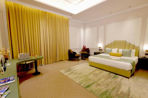 a bedroom with a bed and a desk in a room at The Tivoli New Delhi in New Delhi