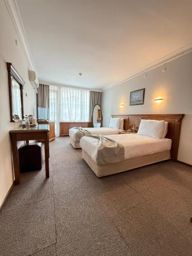 a hotel room with two beds and a desk at OTEL KÂYA in Izmir