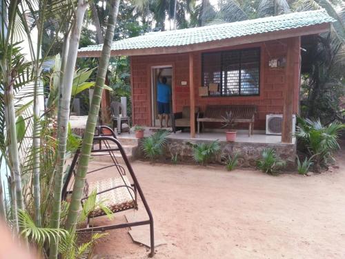a small house with a person standing in the doorway at Tendulkar Beach Resort in Diveagar