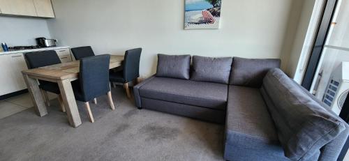a living room with a couch and a table at Two bedroom apartment with views in Cheltenham in Cheltenham