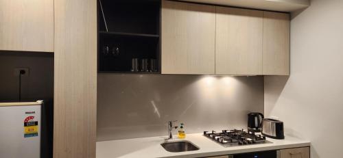 a kitchen with a sink and a stove and cabinets at Two bedroom apartment with views in Cheltenham in Cheltenham