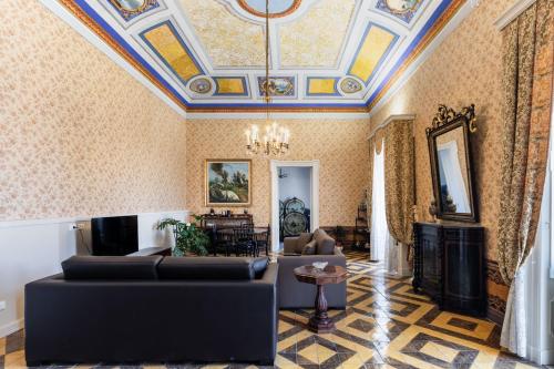a living room with a coffered ceiling and couches at Palazzo Giangreco Luxury Rooms in Avola