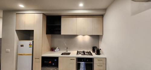 a kitchen with white cabinets and a stove and a refrigerator at Two bedroom apartment with views in Cheltenham in Cheltenham