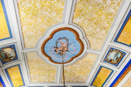 a ceiling with a painting of an angel on it at Palazzo Giangreco Luxury Rooms in Avola