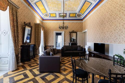 a living room with a couch and a ceiling at Palazzo Giangreco Luxury Rooms in Avola