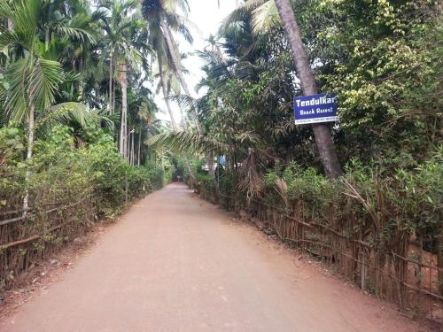 a dirt road with a street sign on it at Tendulkar Beach Resort in Diveagar