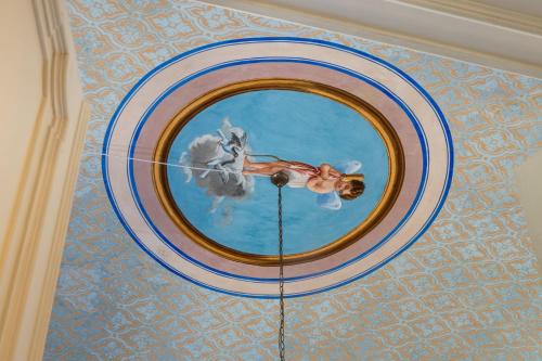 a painting of a woman in a pool on a ceiling at Palazzo Giangreco Luxury Rooms in Avola