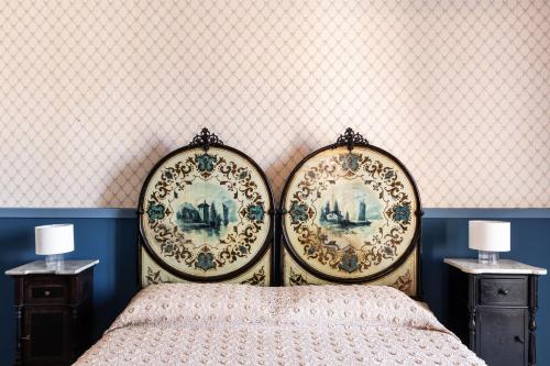 a bedroom with two plates on the wall and a bed at Palazzo Giangreco Luxury Rooms in Avola
