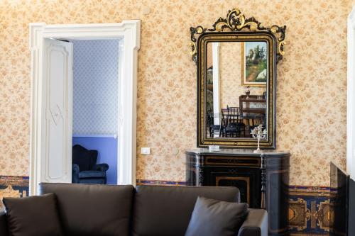 a living room with a couch and a mirror at Palazzo Giangreco Luxury Rooms in Avola