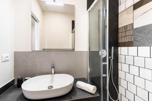 a bathroom with a white sink and a shower at Palazzo Giangreco Luxury Rooms in Avola