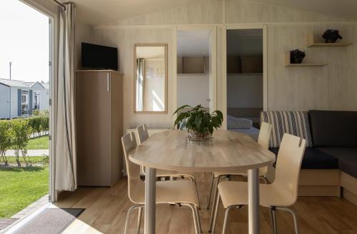 a dining table and chairs in a living room at Vakantiepark Klein Strand - Comfort Chalet 6p in Jabbeke