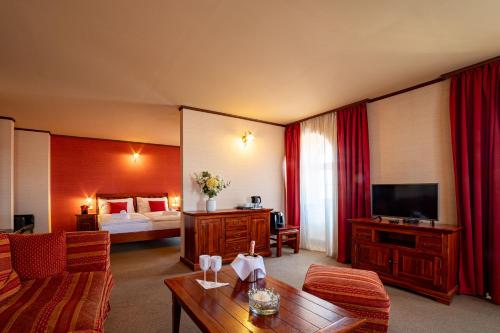 a hotel room with a bedroom and a living room at Zlatý Lev Žatec in Žatec