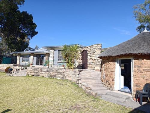 an old stone house with a thatch roof at Alwynskop Guest house in Alwyns Kop