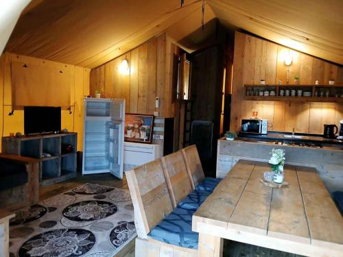 a large kitchen with a table and a refrigerator at Vakantiepark Klein Strand - Glamping 6p in Jabbeke