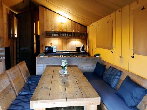 a kitchen with a wooden table in a room at Vakantiepark Klein Strand - Glamping 6p in Jabbeke