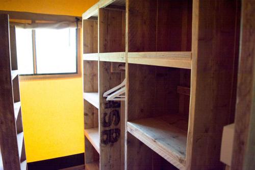 a wooden bookcase with wooden shelves in a room at Vakantiepark Klein Strand - Glamping 6p in Jabbeke