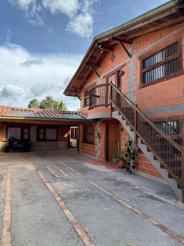 un edificio de ladrillo con una escalera en su lateral en Next to the airport - cute home, en Rionegro