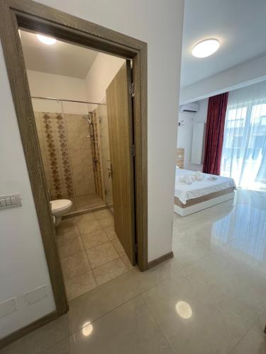 a bathroom with a shower and a bed in a room at Christale Rooms in Năvodari