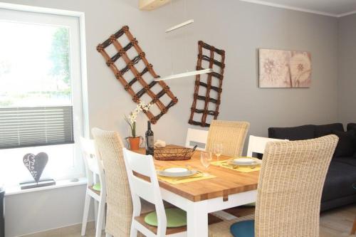 a dining room with a wooden table and chairs at Ferienhaus Skanhuus in Klütz