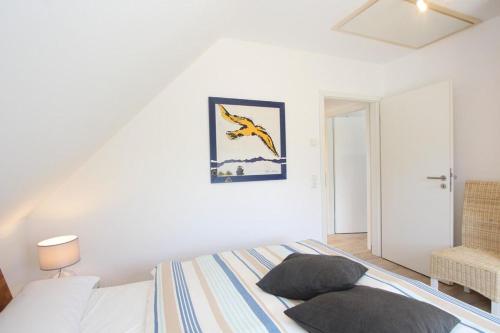 a bedroom with a bed and a picture on the wall at Ferienhaus Skanhuus in Klütz