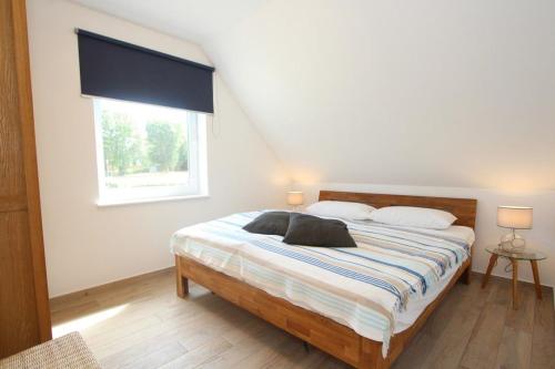 a bedroom with a large bed with a window at Ferienhaus Skanhuus in Klütz