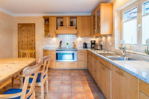 eine Küche mit Holzschränken und einem Holztisch in der Unterkunft Ferienhaus Strandmuschel in Groß Schwansee