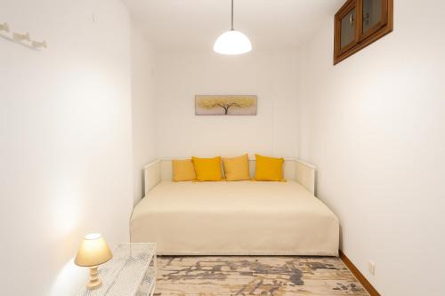 a white bedroom with a bed with yellow pillows at Livadi Hideway Chalet by Ski Alure in Arachova