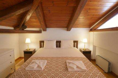 a bedroom with a large bed with two lamps at Livadi Hideway Chalet by Ski Alure in Arachova