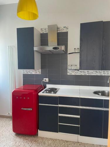 a small kitchen with a red refrigerator in it at La Locomotiva Rooms in Chiaravalle