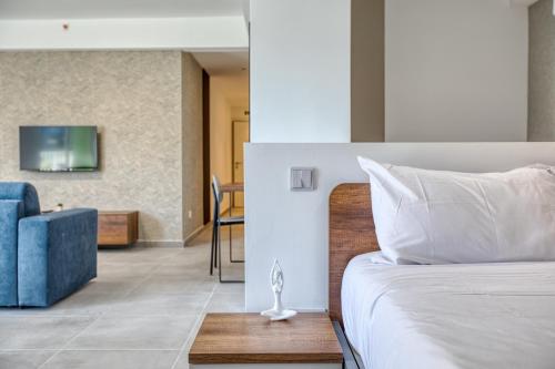 a bedroom with a bed and a blue couch at Stunning apartment Heart of St Julians Sleeps 5 in San Pawl il Bahar