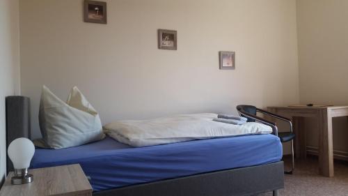 a bed with blue sheets and white pillows in a room at Hotel Deutsches Haus Francop in Hamburg