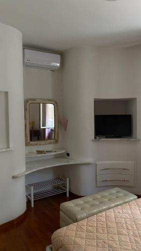 a white room with a tv and a mirror at B&B Villa Pina in Colleferro