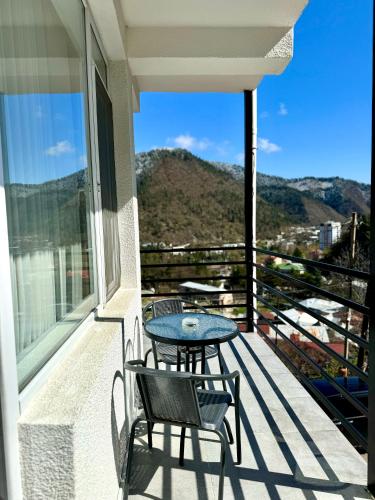 a patio with two chairs and a table on a balcony at Hotel Caucasus Borjomi in Borjomi