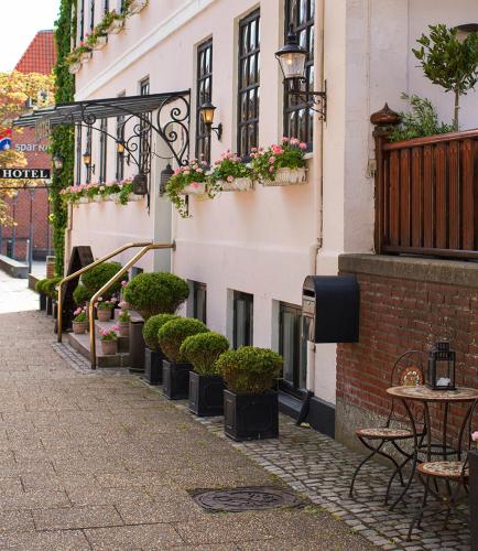 a street with tables and chairs and potted plants at Park Hotel & Vinbar in Frederikshavn