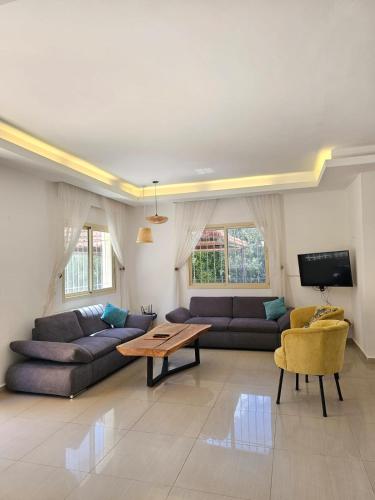 a living room with two couches and a table at Beit Mema in Aḑ Ḑahr
