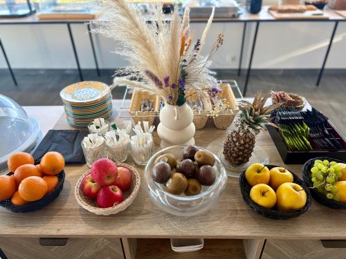 a table with bowls of fruits and vegetables on it at Hotel Carre Noir in Porto-Vecchio