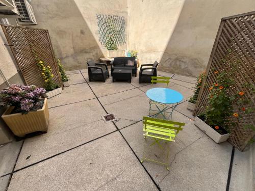 a patio with chairs and a table and plants at The Originals City - Hôtel Saint-Martial, Limoges Centre in Limoges